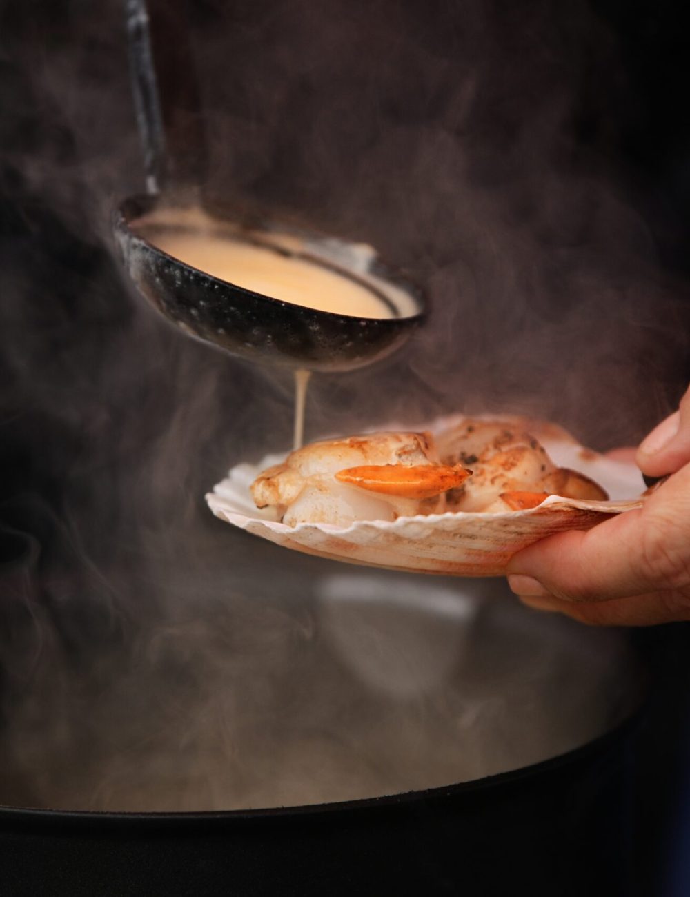 woman-pours-sauce-on-a-scallop-2024-11-26-11-20-12-utc